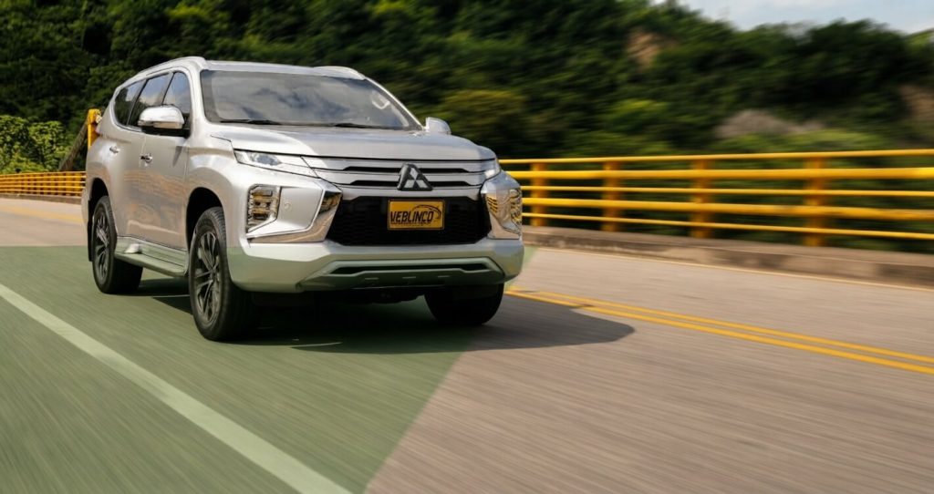 Camioneta blindada Mitsubishi Montero Sport gris en movimiento por carretera en Colombia, de Veblinco.